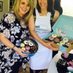 Suranne Jones and Sally Lindsay display cupcakes on sale at Surannes Cupcake Day party
